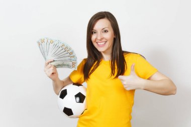 Genç kadın futbol fan eğlenceli veya oyuncunun sarı üniforma gösteren başparmak içinde elinde beyaz arka plan üzerinde izole paket nakit dolar futbol topu. Spor, futbol oyna, heyecan yaşam tarzı kavramı.