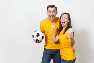 Eğlenceli deli neşeli duygusal genç çift, kadın, erkek, futbol taraftarları destek ekibi ile futbol topu beyaz arka plan üzerinde izole sarı üniforma neşelen. Spor, Aile Eğlence, yaşam kavramı.