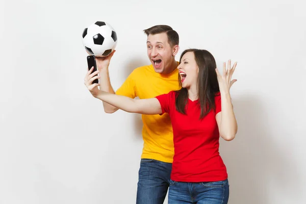 Τρελή διασκέδαση που ασχολούνται νεαρό ζευγάρι, άνδρας, γυναίκα που κάνει selfie στο κινητό τηλέφωνο, τους οπαδούς του ποδοσφαίρου να φτιάξει ομάδα υποστήριξης με μπάλα ποδοσφαίρου που απομονώνονται σε λευκό φόντο. Αθλητισμός, οικογενειακή αναψυχή, αντίληψη του τρόπου ζωής. — Φωτογραφία Αρχείου