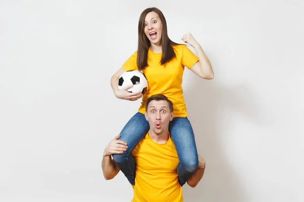 Inspirado jovem casal, mulher sentar-se sobre ombros de homem, fãs com bola de futebol torcendo time de futebol favorito expressivo gesticulando mãos isoladas no fundo branco. lazer familiar, conceito de estilo de vida . — Fotografia de Stock