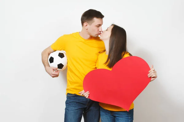 Pareja inspirada, mujer, hombre, fans con pelota de fútbol, gran corazón rojo alegría equipo de fútbol favorito expresivo gesticular manos aisladas sobre fondo blanco. Familia beso concepto de estilo de vida. Copiar espacio . —  Fotos de Stock