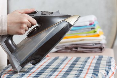 Demir tutan kırpılmış fotoğraf kadın el kadar kapatın. Görev yapan ev hanımı