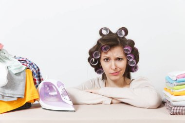 Curlers saç ışık giyim aile giyim Ütü Masası üzerine demir ile Ütü ile sıkıntılı ev kadını. Beyaz arka plan üzerinde izole kadın. Temizlik kavramı. Kopya alanı reklam için.