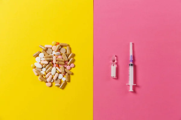 Leki okrągłe kolorowe tabletki, kapsułki, tabletki ułożone Abstrakcja na żółtym tle różowy. Aspiryna, ampułka, pusty igłę. Zdrowia, leczenie, wybór, pojęcie zdrowego stylu życia. Miejsce. — Zdjęcie stockowe