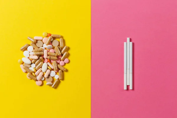 Medicinering vit färgglada runda tabletter ordnade abstrakt tre cigaretter på gul färgbakgrund. Kapsel piller för design. Behandling, val hälsosam livsstilskoncept. Kopiera utrymme annons. — Stockfoto