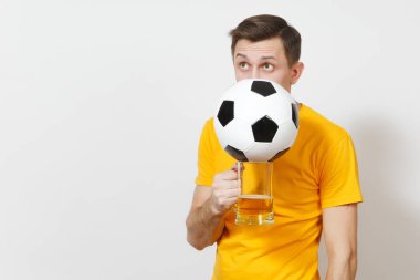 Genç neşeli Avrupa adam, fan veya arkasında bira kupa bira, futbol topu tezahürat favori futbol takımı beyaz arka plan üzerinde izole sarı üniforma gizle Player'da eğlenceli. Spor, oyun, yaşam kavramı.