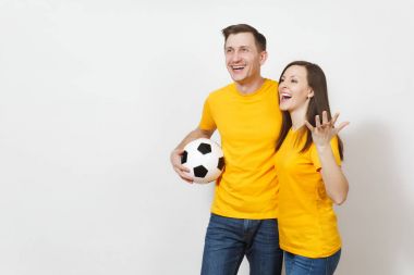 Eğlenceli deli neşeli duygusal genç çift, kadın, erkek, futbol taraftarları destek ekibi ile futbol topu beyaz arka plan üzerinde izole sarı üniforma neşelen. Spor, Aile Eğlence, yaşam kavramı.