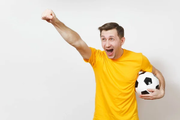 Inspirado joven europeo hombre, ventilador o jugador en uniforme amarillo sostienen pelota de fútbol, animar equipo de fútbol favorito, expresivo gesticular manos aisladas sobre fondo blanco. Concepto de estilo de vida. Copiar espacio . —  Fotos de Stock