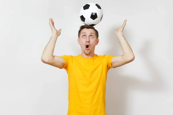 Вдохновлённый молодой веселый европейский мужчина, фанат или игрок в жёлтой форме держатся за голову футбольного мяча, болеют любимой футбольной команды изолированы на белом фоне. Спорт, футбол, концепция здорового образа жизни . — стоковое фото