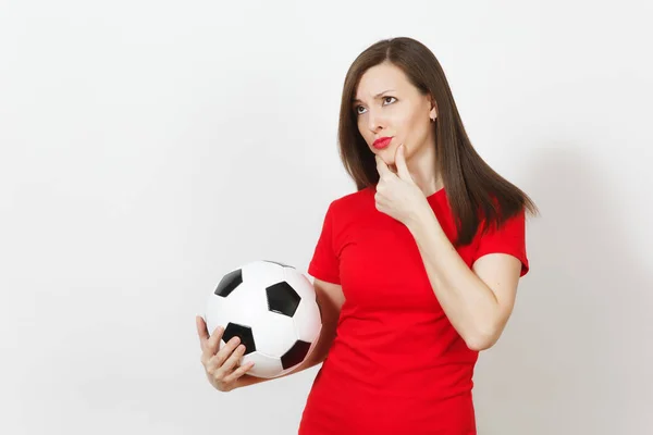 かなり欧州若い物思いにふける思慮深い女性、フットボールのファンまたは赤い制服を着て白い背景に分離された古典的なサッカー ボールを保持しているプレーヤー。スポーツ、サッカー、健康、健康的なライフ スタイル コンセプトを再生. — ストック写真