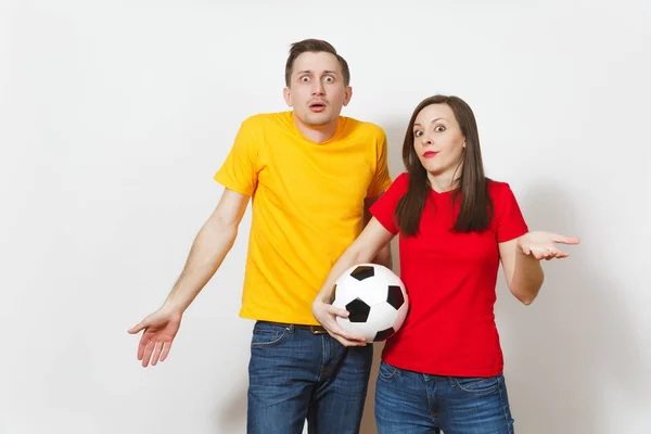 Triste chateado jovem casal, mulher, homem, fãs de futebol em amarelo uniforme vermelho com bola de futebol animar a equipe se preocupa em perder equipe isolada no fundo branco. Esporte, lazer familiar, conceito de estilo de vida . — Fotografia de Stock