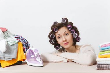 Curlers saç ışık giyim aile giyim Ütü Masası üzerine demir ile Ütü ile genç güzel ev kadını. Beyaz arka plan üzerinde izole kadın. Temizlik kavramı. Kopya alanı reklam için.