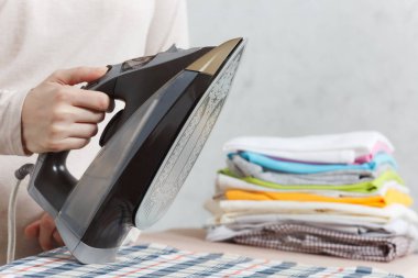 Demir tutan kırpılmış fotoğraf kadın el kadar kapatın. Görev yapan ev hanımı