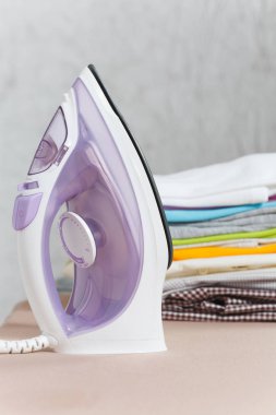 Buharlı Ütü, Çamaşırhane, yıkanmış renkli elbise Ütü kadar yakın aile giyim üzerine Ütü Masası beyaz arka plan üzerinde izole. Temizlik kavramı. Reklam için yer kopyalayın. Metin için yer.