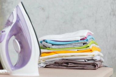 Buharlı Ütü, Çamaşırhane, yıkanmış renkli elbise Ütü kadar yakın aile giyim üzerine Ütü Masası beyaz arka plan üzerinde izole. Temizlik kavramı. Reklam için yer kopyalayın. Metin için yer.