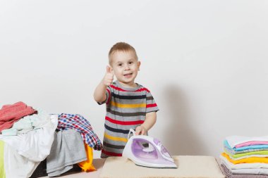 Mutlu küçük çocuk başparmak yukarı, gemide aile giyim demir ile Ütü göster. Beyaz arka plan üzerinde izole ev işleri ile yardım çocuk. Özerklik çocuk kavramı teşvik. Kopyalama alanı reklam.
