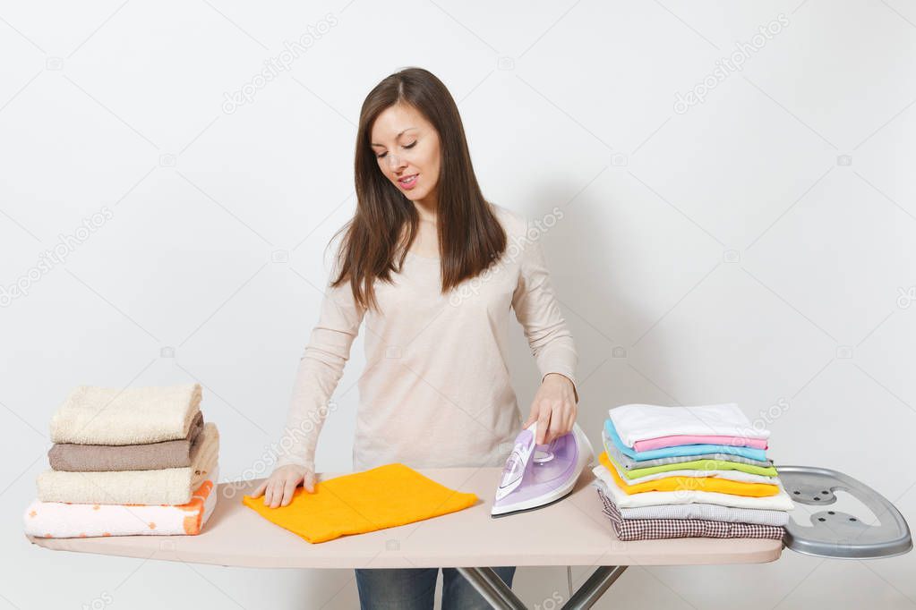 Young attractive housewife in light casual clothes ironing famil
