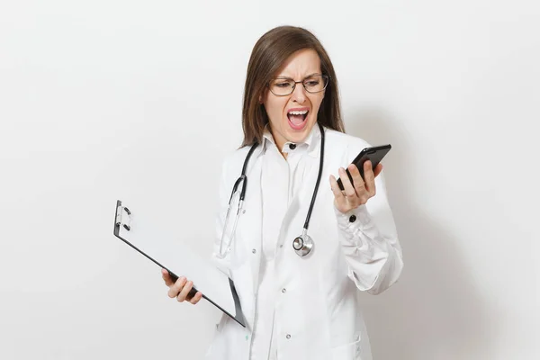 Mujer doctora conmocionada con estetoscopio, aislada sobre fondo blanco. Doctora en bata médica hablar en el teléfono móvil, mantenga la tarjeta de salud en la carpeta del bloc de notas. Concepto de personal sanitario . — Foto de Stock