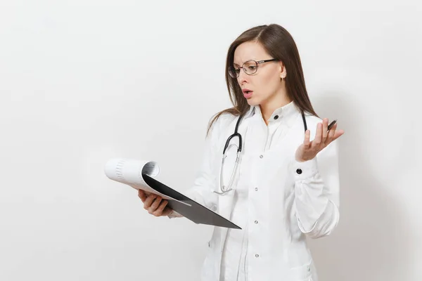 Mujer médica joven enfocada pensativa con estetoscopio, gafas aisladas sobre fondo blanco. Doctora en bata médica con tarjeta de salud en la carpeta del bloc de notas. Concepto de medicina del personal sanitario . — Foto de Stock