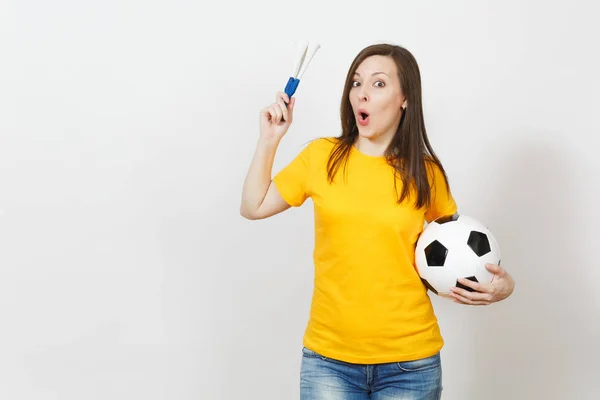 Beautiful European young cheerful happy woman, soccer fan or player in yellow uniform holding football pipe, ball isolated on white background. Sport, play football, health, healthy lifestyle concept.