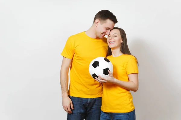 Amusant sourire joyeux émotionnel jeune couple, femme, homme, fans de football en uniforme jaune remonter le moral équipe de soutien avec ballon de football isolé sur fond blanc. Sport, loisirs en famille, concept lifestyle . — Photo