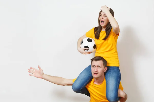 Jeune couple inspiré, femme assise sur les épaules de l'homme, fans avec ballon de football acclamant l'équipe de football préférée mains gesticulantes expressives isolées sur fond blanc. Loisirs en famille, concept lifestyle . — Photo