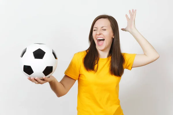 Hermosa joven europea alegre mujer feliz, fanático del fútbol o jugador en uniforme amarillo sosteniendo pelota de fútbol aislado sobre fondo blanco. Deporte, fútbol, salud, concepto de estilo de vida saludable . — Foto de Stock