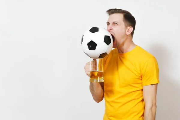 Inspirado joven divertido alegre hombre europeo, ventilador o jugador en amarillo taza de cerveza mordida uniforme pinta, fútbol bola animar equipo de fútbol favorito aislado sobre fondo blanco. Deporte, juego, estilo de vida concepto . — Foto de Stock