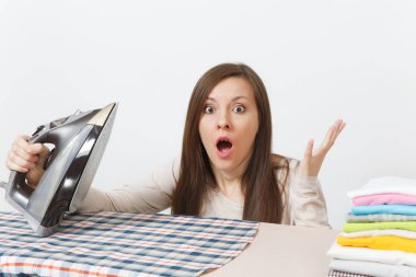 Eğlenceli yakından demir ile Ütü Masası üzerinde giyim şok ev kadını hafif giysiler kareli gömlek, Ütü yorgun. Beyaz arka plan üzerinde izole kadın. Temizlik kavramı. Kopyalama alanı reklam.