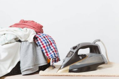 Buharlı Ütü, Çamaşırhane, yıkanmış renkli elbise Ütü kadar yakın aile giyim üzerine Ütü Masası beyaz arka plan üzerinde izole. Temizlik kavramı. Reklam için yer kopyalayın. Metin için yer.