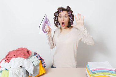 Curlers saç ışık giyim aile giyim Ütü Masası üzerine demir ile Ütü ile genç güzel ev kadını. Beyaz arka plan üzerinde izole kadın. Temizlik kavramı. Kopya alanı reklam için.