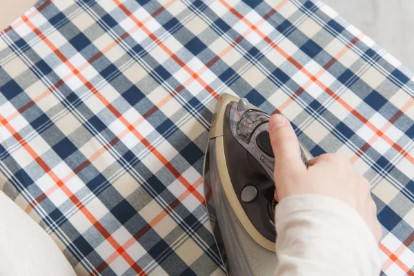 Demir tutan kırpılmış fotoğraf kadın el kadar kapatın. Görev yapan ev hanımı