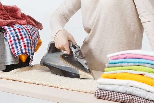 Stäng upp beskurna porträtt hemmafru i ljus casual kläder järn — Stockfoto