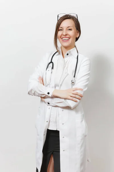 Uśmiecha się, pewnie całkiem młody lekarz kobieta z stetoskop, izolowana na białym tle okulary. Lekarka w medycznych suknia, trzymając się za ręce skrzyżowane. Pracowników służby zdrowia, zdrowia, medycyny pojęcie. — Zdjęcie stockowe