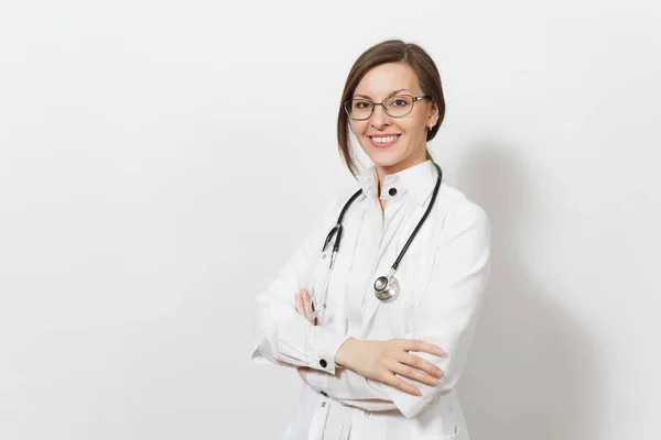Sorridente fiduciosa bella giovane donna medico con stetoscopio, occhiali isolati su sfondo bianco. Medico donna in abito medico tiene le mani piegate. Personale sanitario, salute, concetto di medicina . — Foto Stock