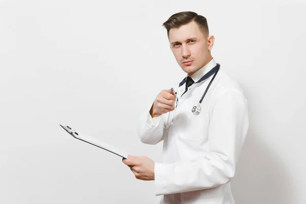 Poważne zamyślony koncentruje się przystojny młody lekarz mężczyzna na białym tle. Lekarz medyczny jednolite, stetoskop karty zdrowia na folderze Notes. Koncepcja medycyna zdrowia pracowników służby zdrowia. — Zdjęcie stockowe