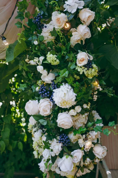 Bonita e requintada decoração da celebração do casamento no meio de um jardim verde. Quadro retangular de madeira decorado com um pano rosa, um monte de flores leves e bagas azuis — Fotografia de Stock