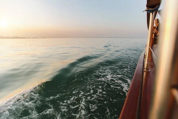 Manzara, deniz manzarası A güzel view güneş kıyı şeridi ve açık açık gökyüzü yansıtılır masmavi dalgalı deniz altın korkuluk ile ahşap bir kahverengi yat güverteden açar