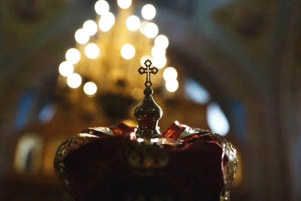 Esküvő az ortodox egyházban. Ünnepi koronát a fej, a vőlegény, a fehér ing háta mögött a pap a reverenda, a sötét háttérben a templombelső — Stock Fotó