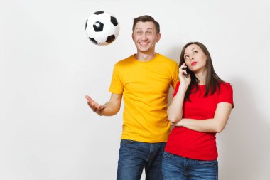 Genç adam, kayıtsız kadın cep telefonunda söz eğlenceli nişanlı, futbol taraftarları destek takımı kadar beyaz arka plan üzerinde izole futbol topu ile teselli. Spor, çift, Aile Eğlence, yaşam kavramı.