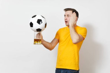 Üzgün üzgün genç Avrupa adam, fan veya oyuncu sarı üniforma tutun bira kupa bira şaşkın, futbol topu favori futbol takımı beyaz arka plan üzerinde izole tezahürat. Spor, oyun, yaşam kavramı.