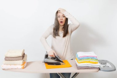 Genç ilgili yorgun şok ev kadını ışık elbise giyim, Ütü havlu Buharlı Ütü ile Ütü Masası üzerinde. Beyaz arka plan üzerinde izole kadın. Temizlik kavramı. Kopyalama alanı reklam.