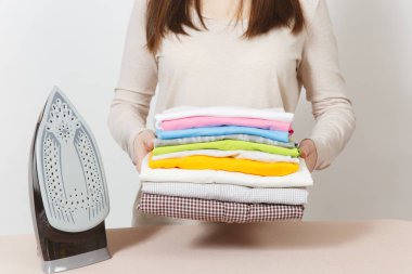 Aile giyim demir ile Ütü Masası üzerinde tutarak hafif rahat kıyafetler içinde kırpılmış portre ev hanımı kapatın. Beyaz arka plan üzerinde izole kadın. Temizlik kavramı. Kopya alanı reklam için.