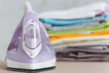 Buharlı Ütü, Çamaşırhane, yıkanmış renkli elbise Ütü kadar yakın aile giyim üzerine Ütü Masası beyaz arka plan üzerinde izole. Temizlik kavramı. Reklam için yer kopyalayın. Metin için yer.