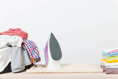 Buharlı Ütü, Çamaşırhane, yıkanmış renkli elbise Ütü kadar yakın aile giyim üzerine Ütü Masası beyaz arka plan üzerinde izole. Temizlik kavramı. Reklam için yer kopyalayın. Metin için yer.