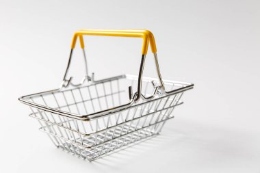 Metal Market sepeti üzerindeki beyaz arka plan üzerinde izole sarı plastik öğelerle süpermarkette alışveriş için kapatın. Alışveriş kavramı. Kopya alanı reklam için