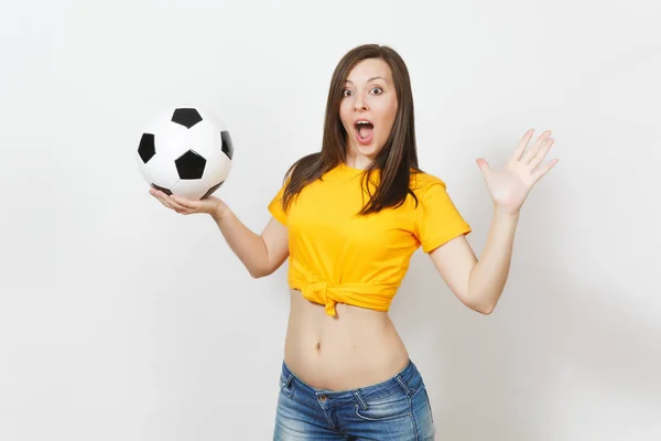 Beautiful European young strong slim sexy woman, football fan or player in yellow uniform holding soccer ball isolated on white background. Sport, play football, health, healthy lifestyle concept.