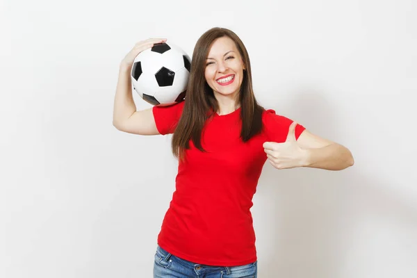 美しいヨーロッパの若い女性、フットボールのファンまたは赤のユニフォームで選手は、白い背景の上親指のアップ、古典的なサッカー ボールの分離を保持を示しています。スポーツ、サッカー、健康、健康的なライフ スタイル コンセプトを再生. — ストック写真