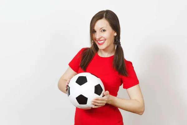 Smiling European young woman, two fun pony tails, football fan or player in red uniform holding classic soccer ball isolated on white background. Sport play football health, healthy lifestyle concept.