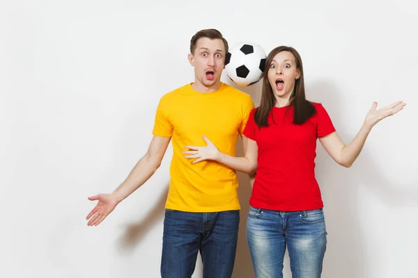 Fun crazy cheerful European young couple, woman, man, football fans in yellow red uniform hold play soccer ball isolated on white background. Sport, game football, family leisure, lifestyle concept. — Stock Photo, Image